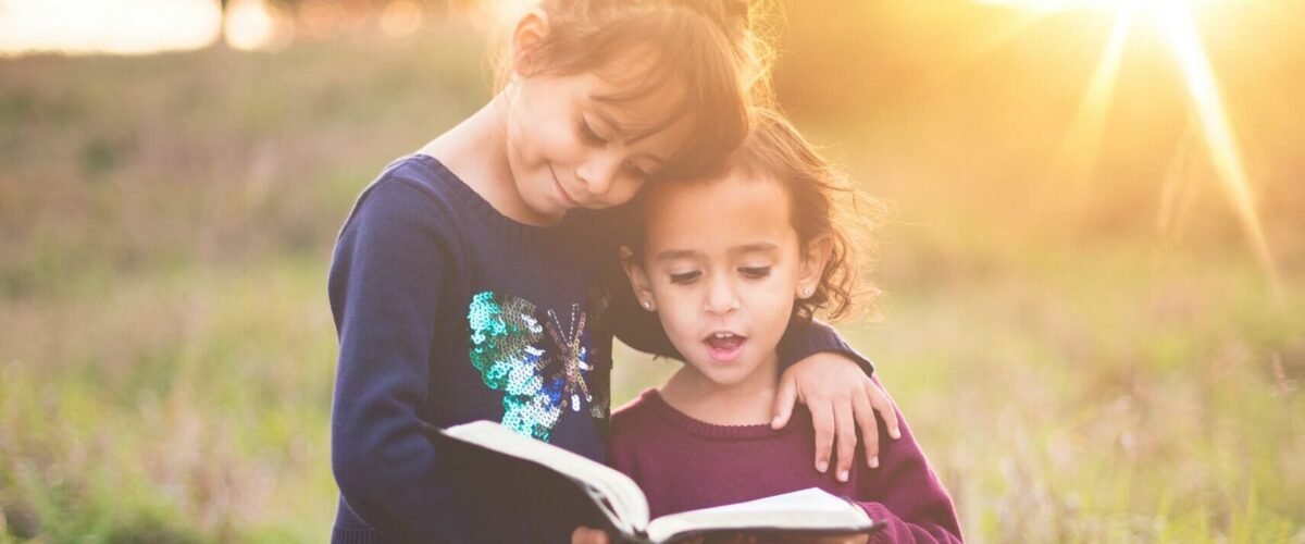 Deux petites filles lisent un livre biographique sonore